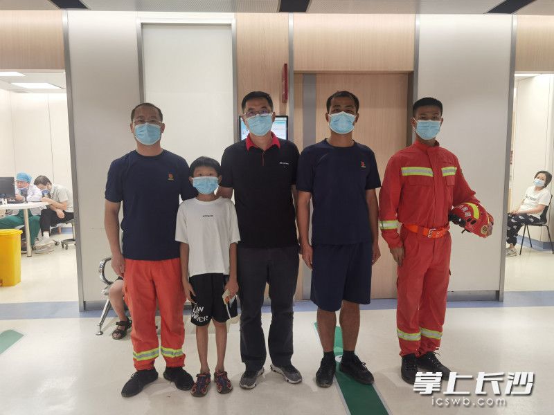 女子丈夫（中）赶到医院，向长沙消防指战员表达谢意。