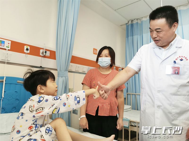 湖南省儿童医院党委书记赵卫华伯伯和芊芊“约定”好好读书，芊芊妈妈在一旁笑容满面。