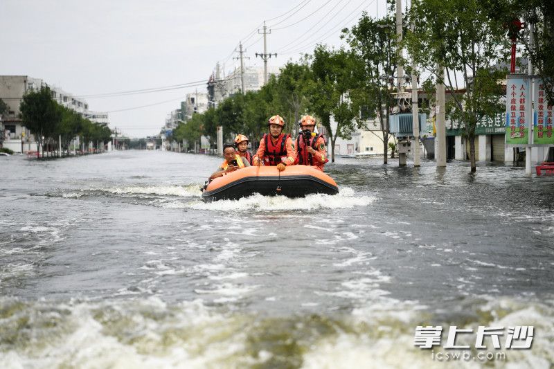 余金成（右二）和其他消防员一起勘察积水水情，转移被困群众。长沙晚报通讯员 唐雄杰 全媒体记者 刘琦 摄影报道