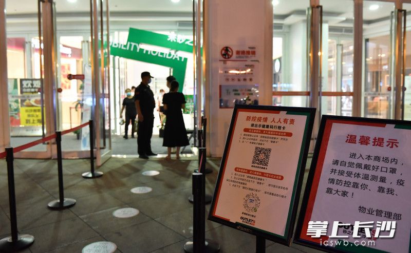 砂之船奥莱商场门口市民必须按疫情防控的要求有序进入商场。