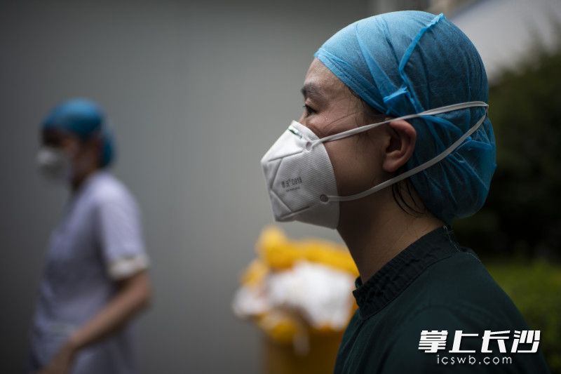 刚刚脱下防护服，一名护士脸上挂满了长时间戴着口罩的印子。