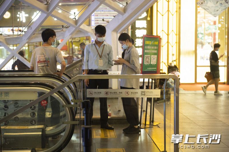 不少商家都在入口进行双码验证和体温测量。