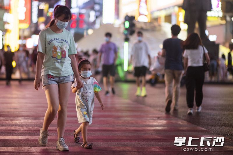 在黄兴南路商业步行街，市民戴着口罩出行。