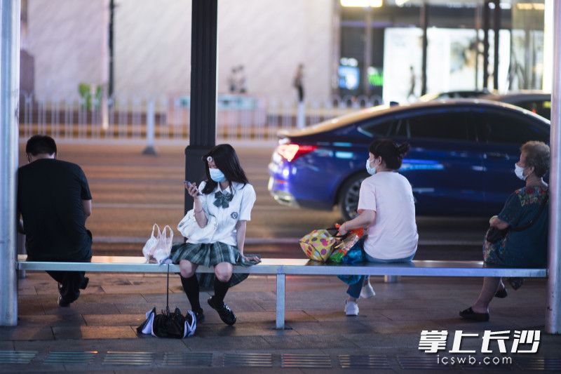 在公交车站，市民有意识的间隔坐开候车。