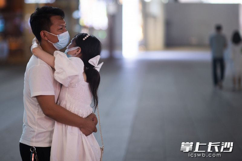 一对情侣戴着口罩在一起拥抱。