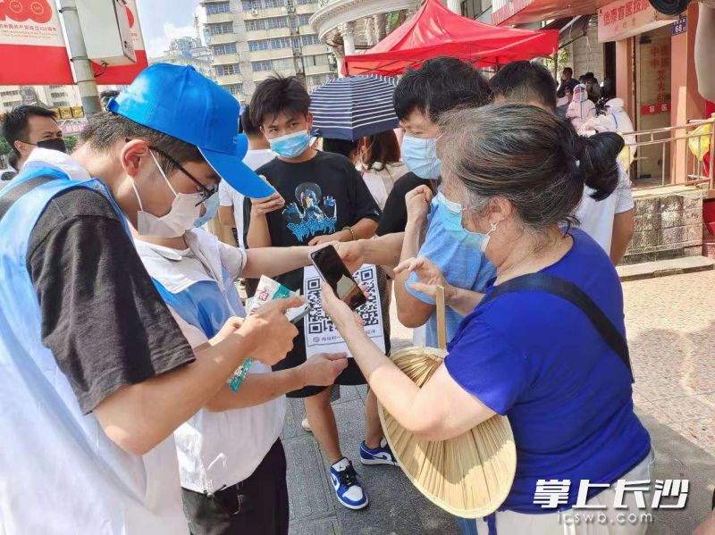 志愿者帮助临检老人进行手机注册。长沙晚报全媒体记者 王斌 摄