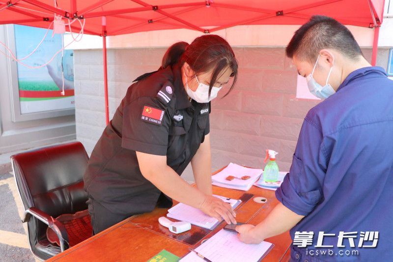 物业保安正在小区门口登记出入人员信息，并查看健康码和行程码。 长沙晚报通讯员 周游 通讯员 阮霖浩 摄影报道
