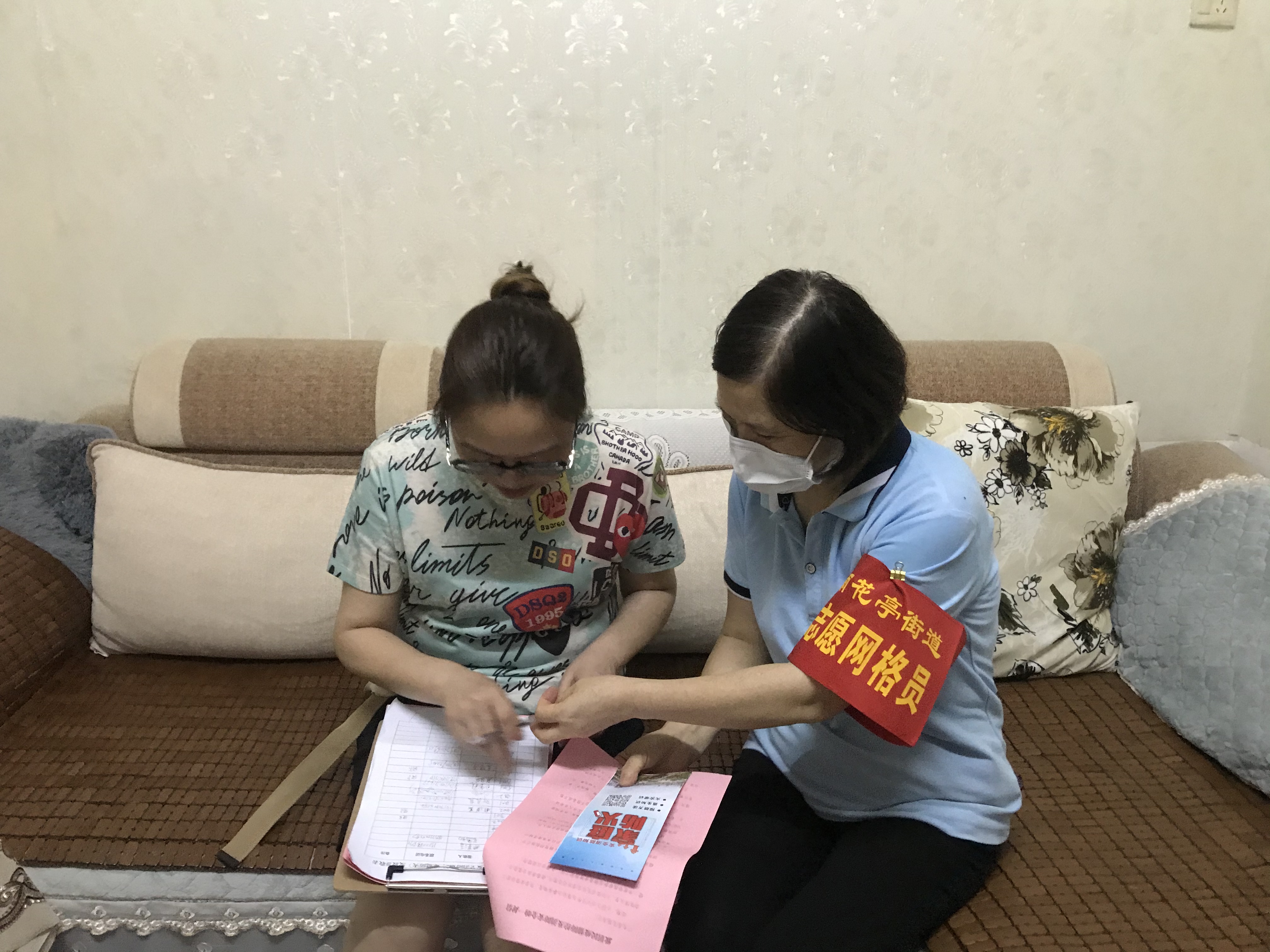 雨花亭街道内，工作人员和志愿者走门入户开展防疫宣传。