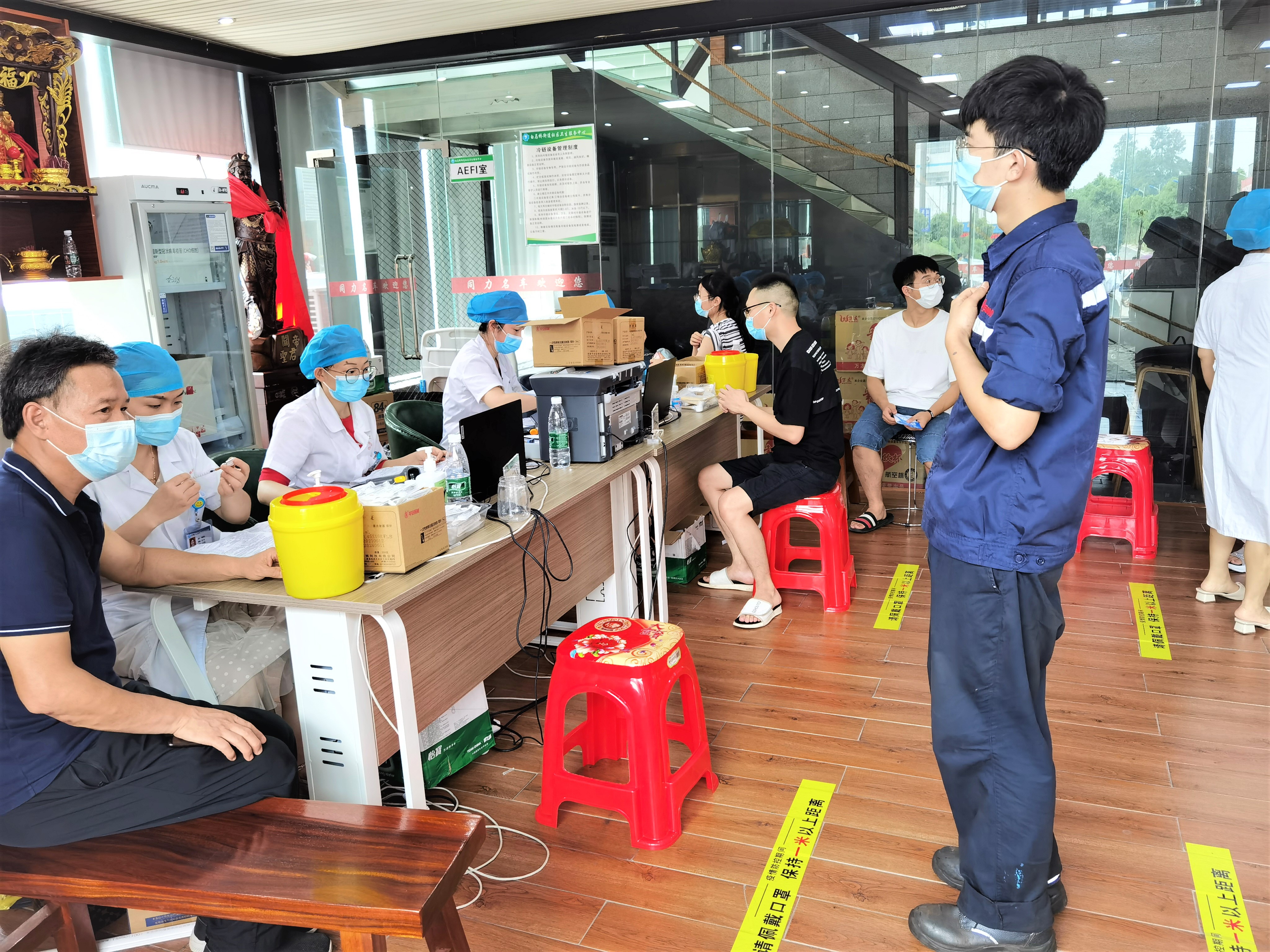 在宁乡市白马桥街道，一家汽车4S店蝶变成为新冠疫苗接种点，佩戴口罩的群众正在有序排队接种疫苗。长沙晚报全媒体记者 张禹 摄