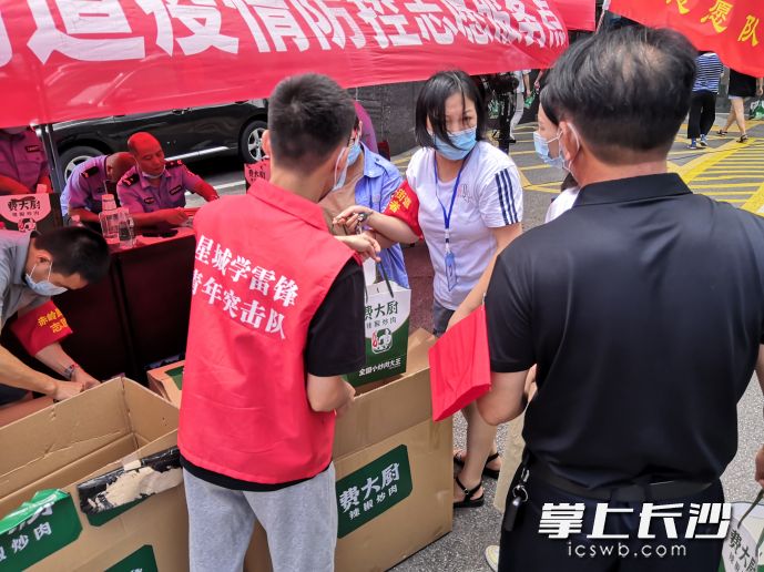 市星城学雷锋志愿服务发展中心青年志愿者将爱心企业捐赠的150份爱心餐送到天心区赤岭路街道乾城嘉园小区一线工作人员手中 。