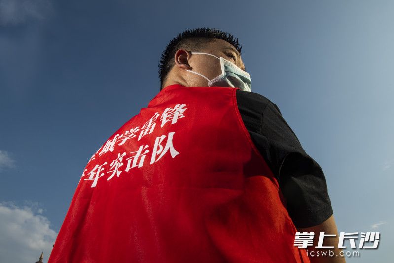 98年出生的高飞岩是长沙“星城学雷锋 青年突击队”的队员，在烈日下他正将爱心物资搬运到车上。图片均为 长沙晚报全媒体记者 黄启晴 摄