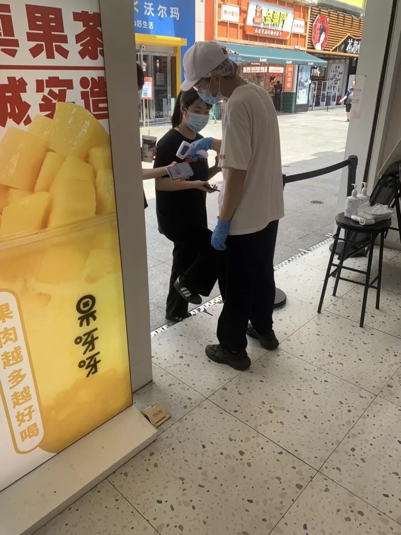 果呀呀门口，工作人员正在为市民测提问、查双码。