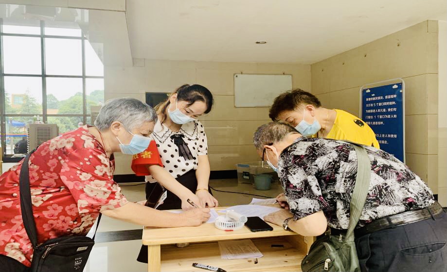 志愿者在老人、孩童优先通道为老年人热情服务。 