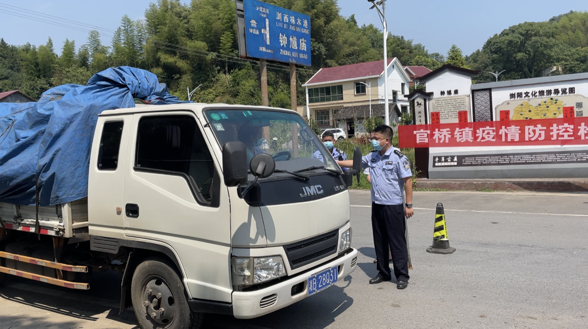 官桥镇工作人员正对来往车辆及司乘人员排查登记，严格核查“双码”、测温。