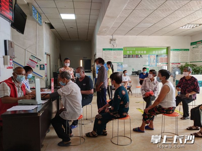 在宁乡市坝塘镇，卫生院工作人员为排队接种疫苗的老人专门准备了凳子，并提醒他们保持安全间隔距离。 长沙晚报通讯员 崔祥武 供图