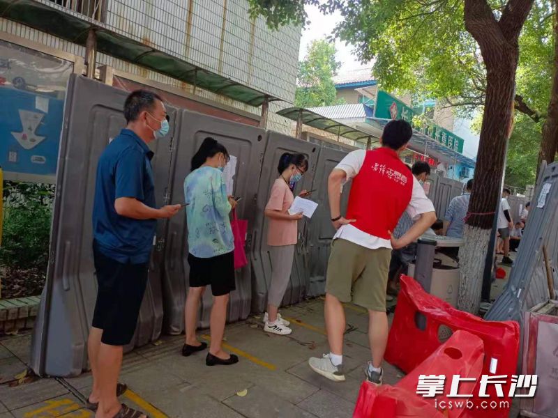 志愿者维持排队秩序。 受访者供图