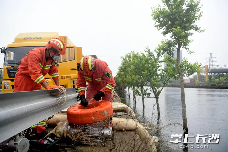 长沙消防指战员为高速公路的淹没路段进行排水。
