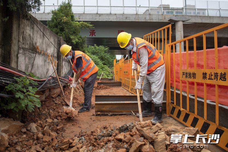 施工人员佩戴口罩，正在清理碎石。