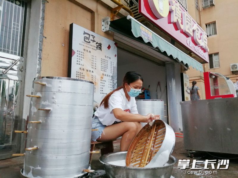 小区内的包子店老板娘在清洗工具准备开业。