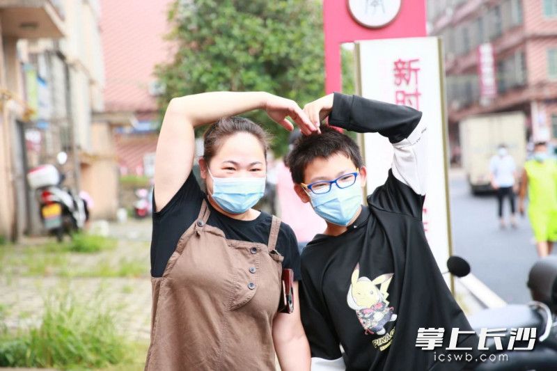 一对母子合手比心，庆祝这幸福一刻。
