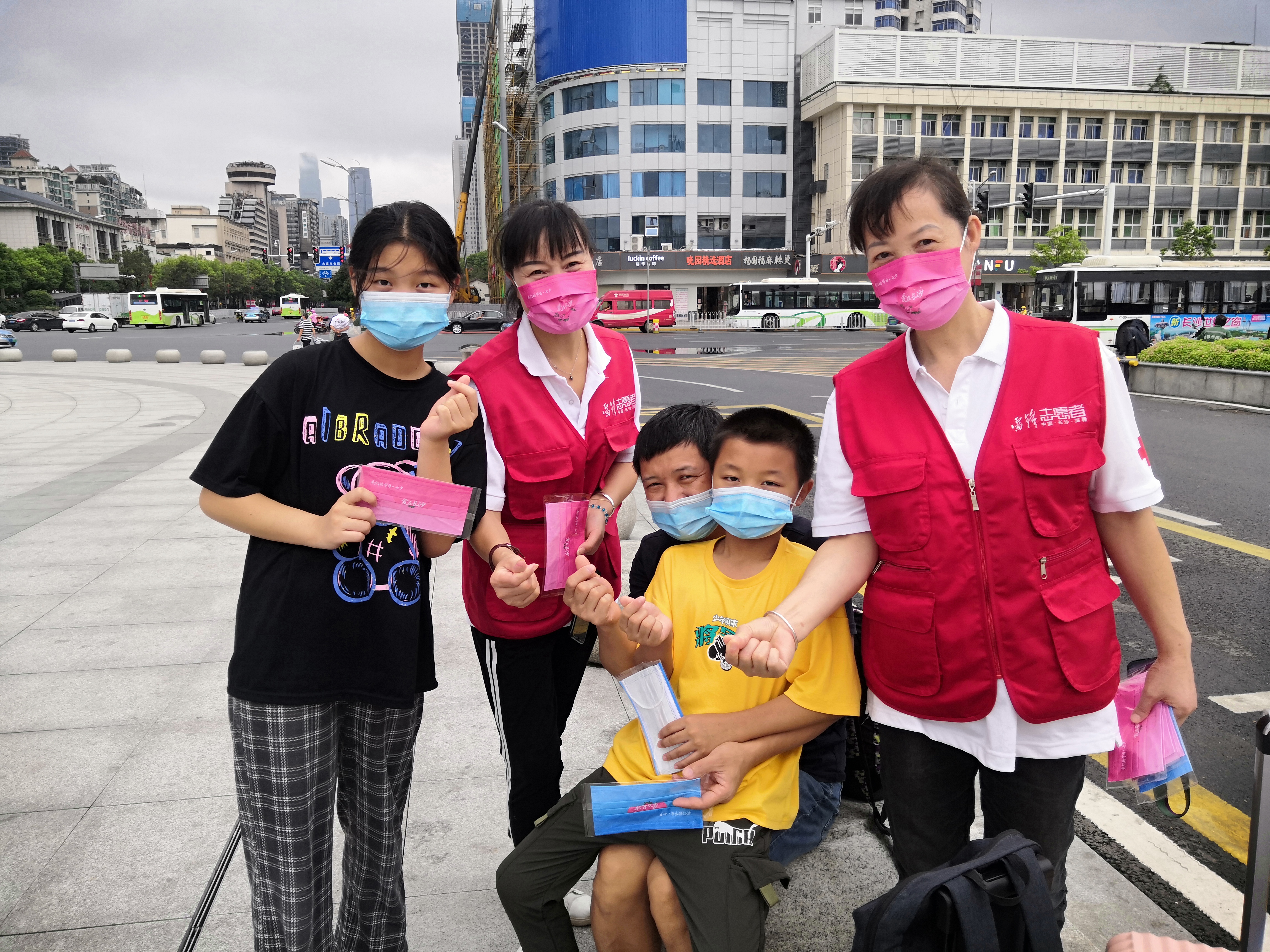 芙蓉区防疫志愿者在火车站为市民派发“爱心口罩”。