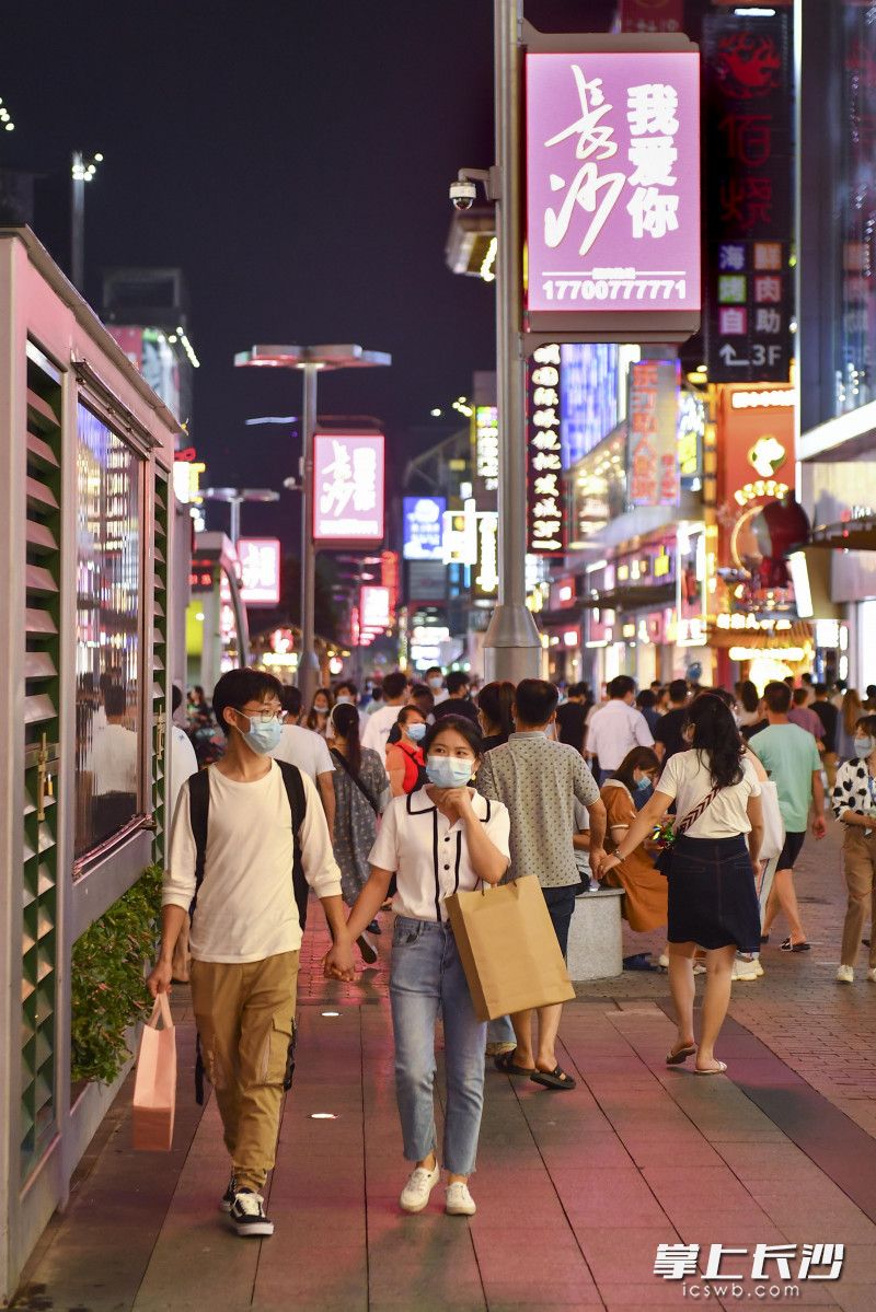 市民、游客佩戴口罩在黄兴路步行街游玩。