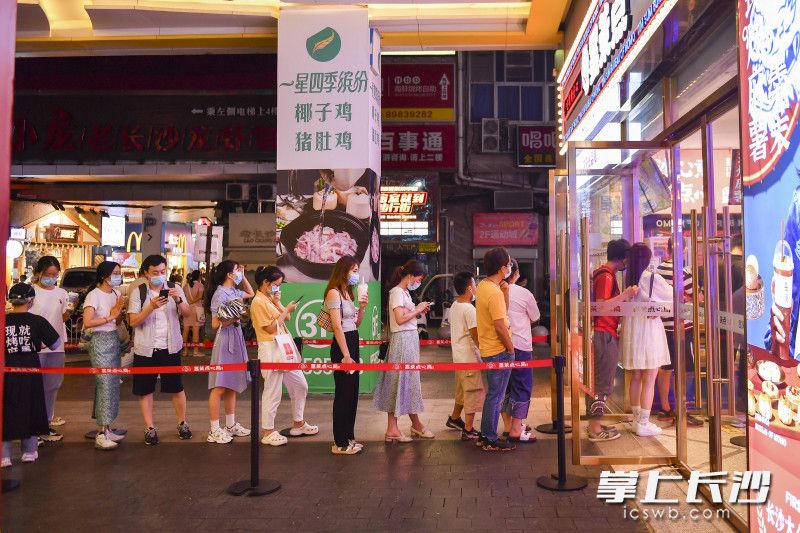 游客佩戴口罩排队购买食品。