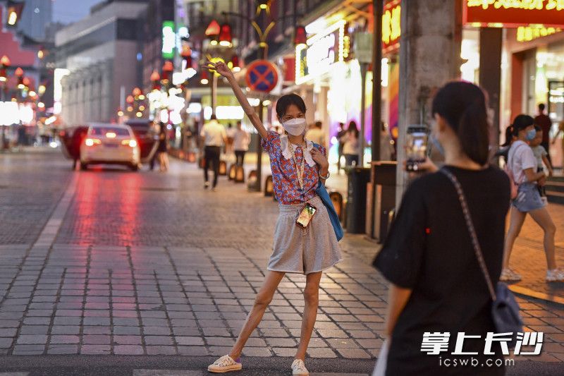 游客佩戴口罩在坡子街“打卡”。