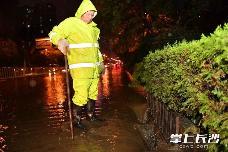 8月18日晚，银杉路谷岳路口，岳麓市政工作人员正在清理排水口加大排水。