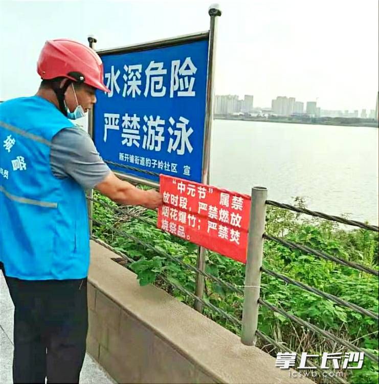 新开铺街道工作人员在湘江风光带张贴文明祭祀宣传标语。长沙晚报通讯员 张觉新   供图