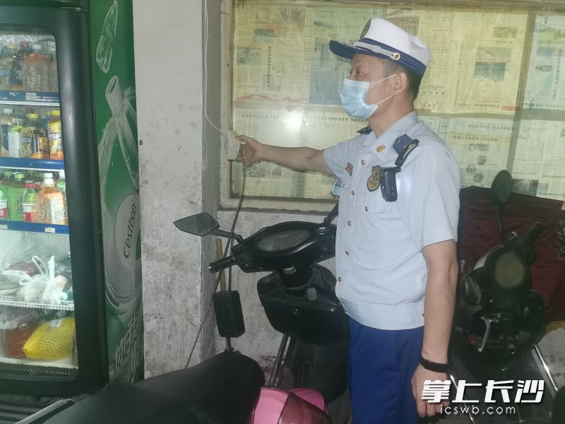 消防监督员对电动自行车违规停放和充电的行为依法进行处罚。均为雨花消防 供图