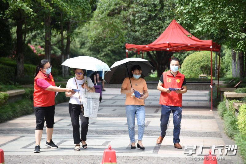 工作人员在小区向过往人员发放普查宣传材料。