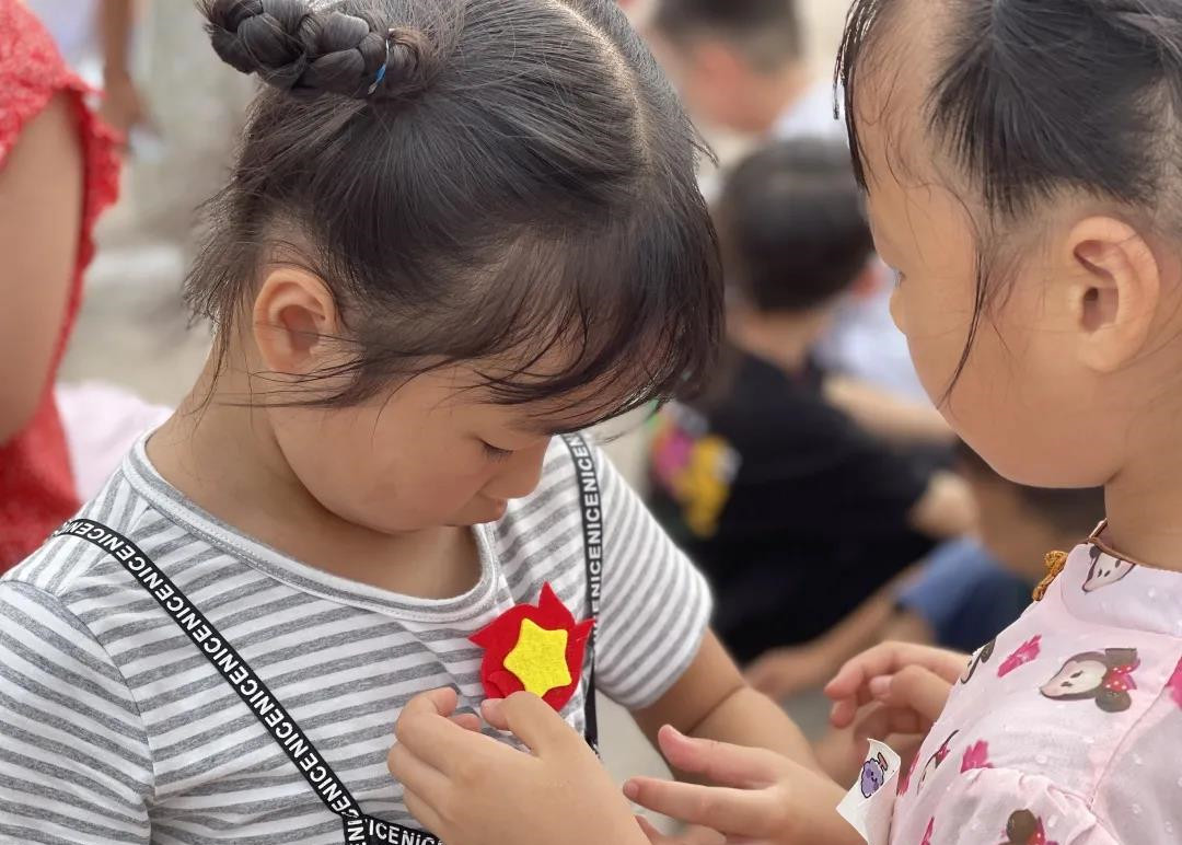 梨塘小学的同学们佩戴“胜利花”。