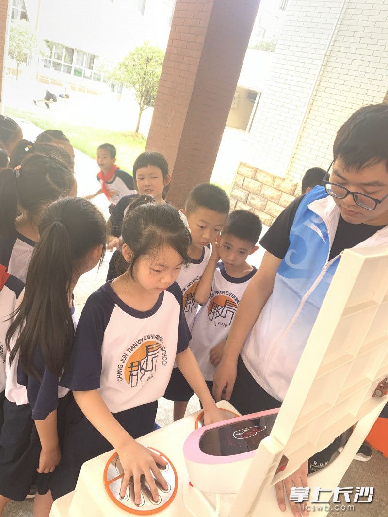 学生在体验科普大篷车科技展品。