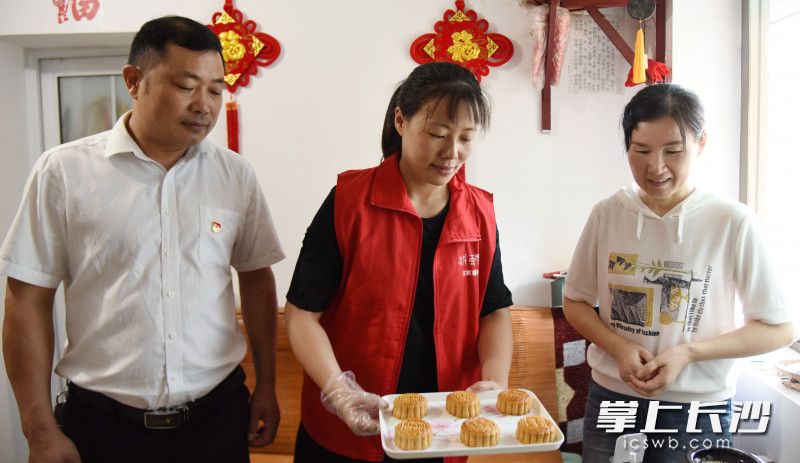 孙家闯（左）与志愿者一同将做好的月饼送到社区困难群众家中。