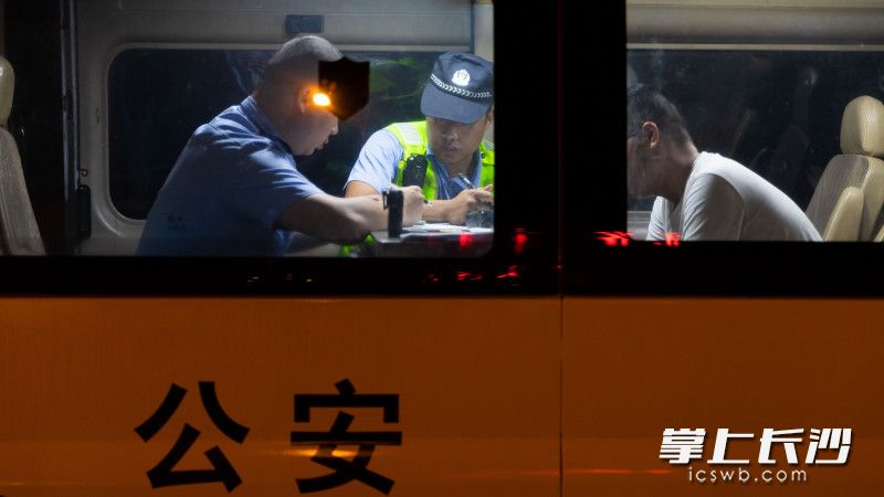 周某因涉嫌酒驾被带上警车调查。