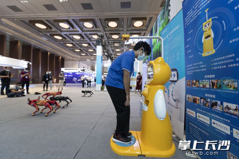 参会嘉宾在体验机器人快速体检。
