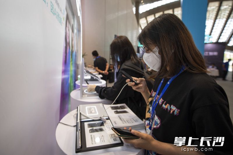 在科大讯飞展台，参会嘉宾在体验科大讯飞的实时翻译机。