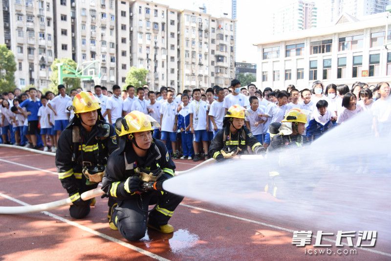消防指战员出水枪扑灭“大火”。