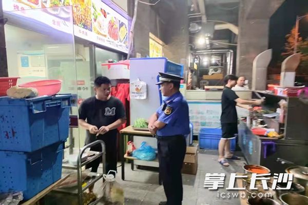 执法人员对相关门店经营者进行劝导。通讯员 沈文婷 供图