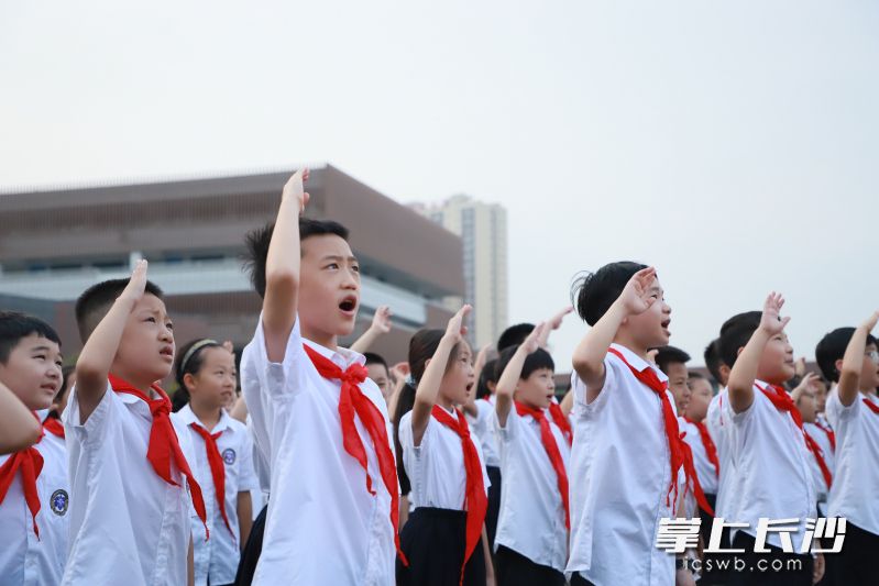 9月29日，长沙康礼·克雷格学校全体师生齐聚操场，举行以“我和我的祖国”为主题的升旗仪式。这是在升旗仪式上，学子们高唱国歌行队礼。