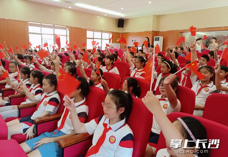 活动现场，同学们挥舞着国旗，唱响《我和我的祖国》。均为长沙晚报全媒体记者 陈良 摄