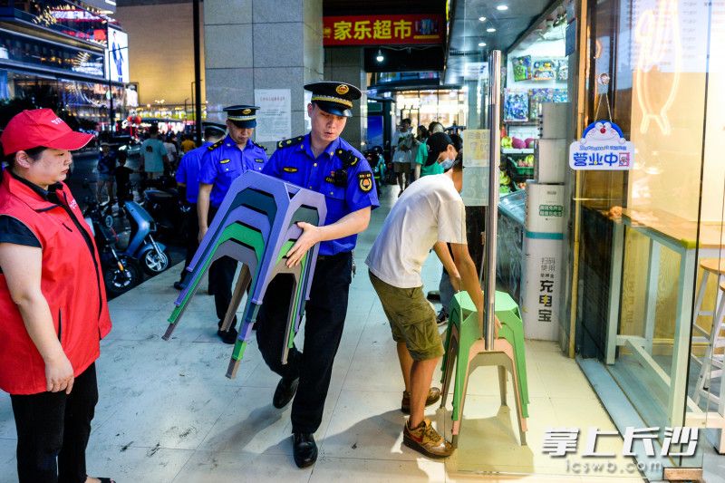 相关部门工作人员及志愿者正在维持街面秩序。