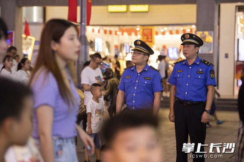 城管队员以巡查和守点相结合的方式，对步行街沿线市容进行管控。