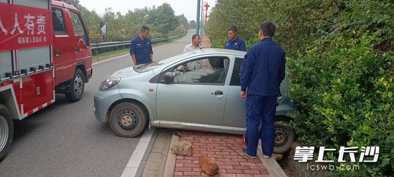 消防员一边抬车，一边往后轮下方垫砖块和石块。长沙晚报通讯员 胡宇波 供图