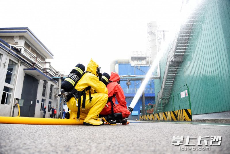 消防员使用室外消火栓对“火势”进行控制。