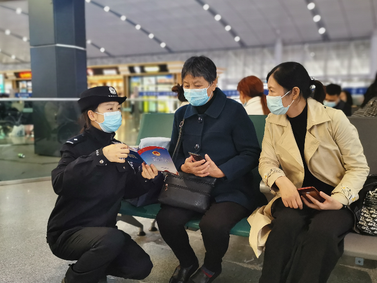 铁警向旅客发放普法宣传手册。