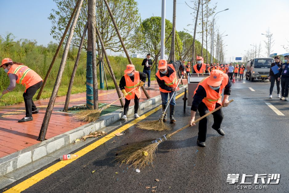 “扫帚”成“武器”，“马路”变“战场”。全媒体记者 陈飞摄