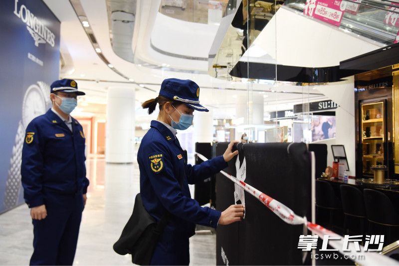 消防监督员对违规设置的商铺依法实施临时查封。