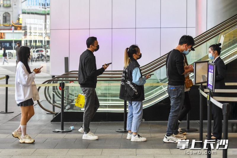 在长沙国金中心，市民接受体温测量进入商场。全媒体记者 郭雨滴 摄